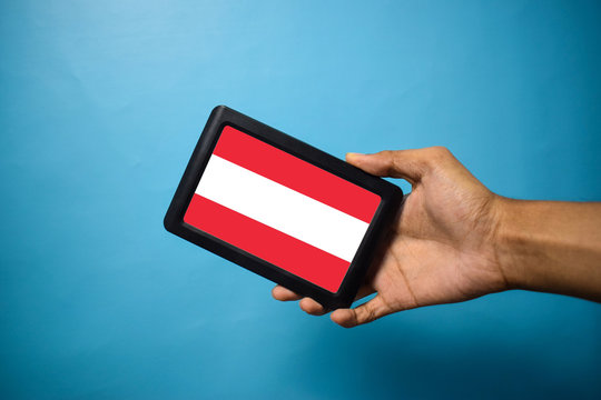 Man holding Smartphone with Flag of Austira. Austria Flag on Mobile Screen isolated On Blue Background
