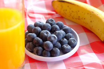 berry fruits, juice and banana on table for breakfast 