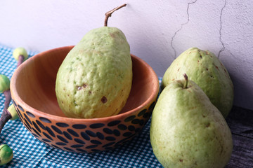 Close up of guava in a wooden bowl on table 
