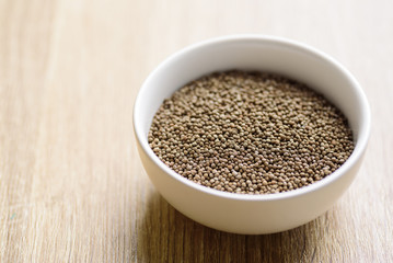 Organic perilla seeds in a bowl on wooden background, healthy herbal seed ingredient in Asian food