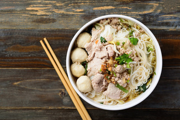 Rice noodles soup with pork and meat ball in a bowl eating by chopsticks,  Asian food, Thai style,...