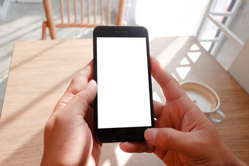 Mockup picture of business man’s hands holding smart phone with white blank screen in modern place