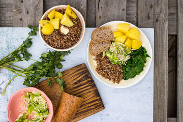 Healthy diverse assorted food plate dinner, lunch with buckwheat porridge, rye bread, spinach, potato, fresh cabbage salad. Vegan, vegetarian diet.