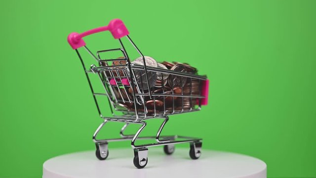 spinning shopping cart full of US coins on green screen