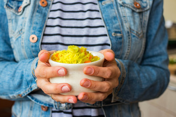 Indian basmati biryani pilaf colorful rice in woman hands with vegetables. Vegan, vegetarian healthy food.