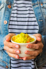 Indian basmati biryani pilaf colorful rice in woman hands with vegetables. Vegan, vegetarian healthy food.