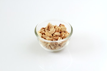 Peanuts in a glass bowl isolated on white background. High protein, 