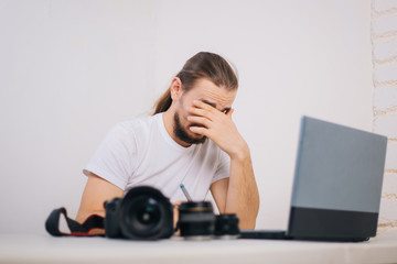 Photographer for processing photos. Workplace with a laptop. Photographer equipment on the table. Retouching photos.