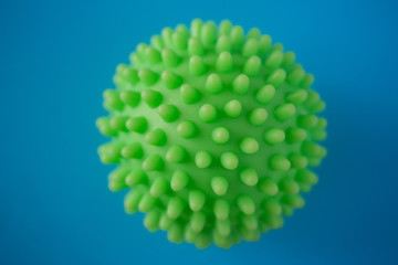 Close up of green spiky coronavirus model isolated on blue background. Pandemic desease spreading worldwide. Medical treatment of the infected people. Healthcare