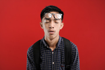 Fototapeta premium Lazy Young Asian Student feeling tired wearing eyeglasses