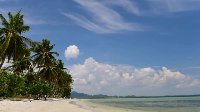 Time lapse of Koh mook island with beach, cloud sky and palm trees moving by the wind at Koh Mook, Trang, Thailand