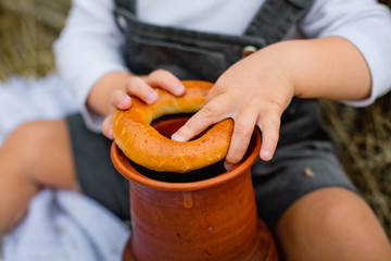 a boy on a picnic in a wheat field eats products from bread and rolls