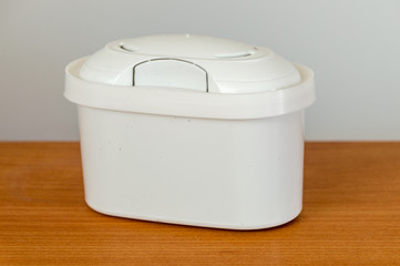 Aqua cartridge filter on wooden table.