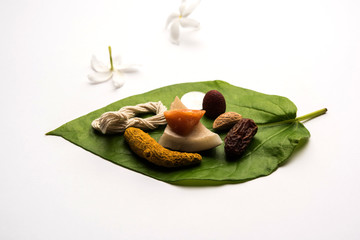 Hindu Puja with betel leaf, supari, janeu, almond, dates, turmeric, dried coconut and jaggery with...