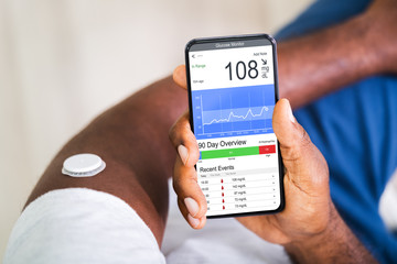 Man Checking Blood Sugar Level On Smart Phone