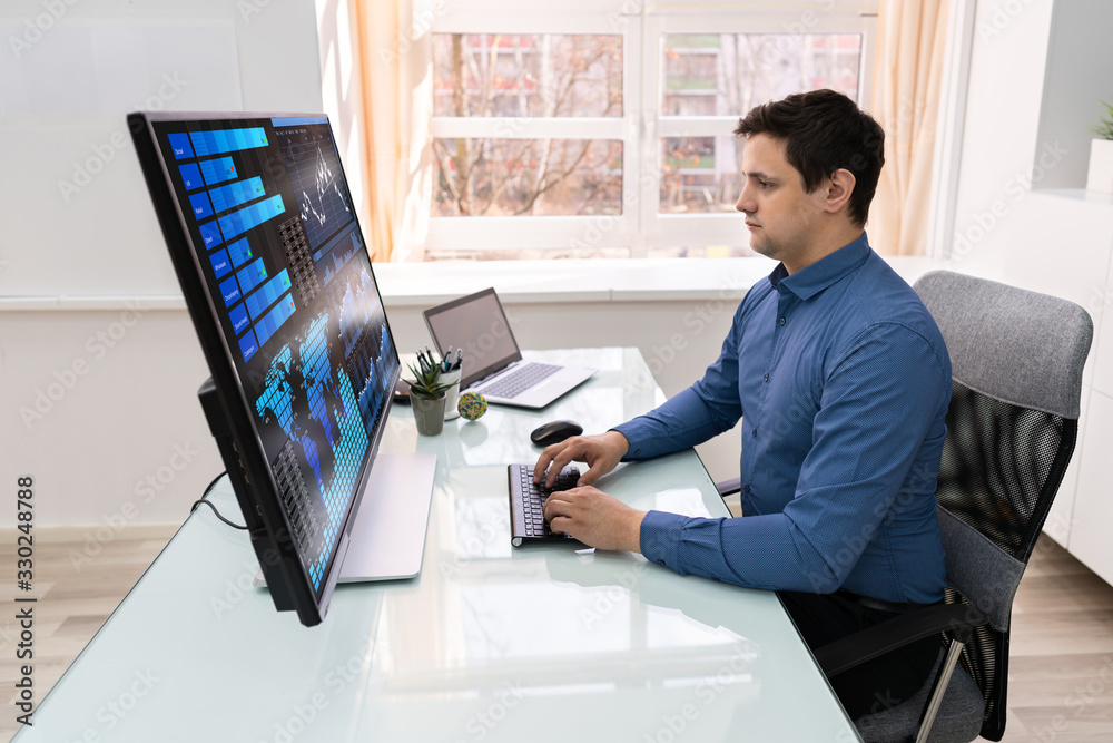 Poster businessman analyzing graphs on computer