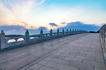 Fototapeta premium Sunset over the Seventeen Hole Bridge in the Summer Palace in Beijing, China