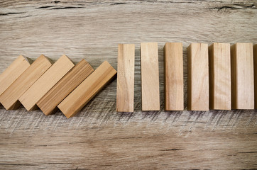 Falling wooden blocks on a wooden background. Close up wooden block  with a business risk management concept