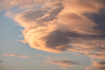 Naklejka na ściany i meble A large golden lenticular cloud formation at sunset