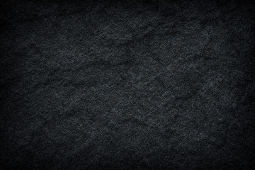 Dark grey / black slate background or texture.