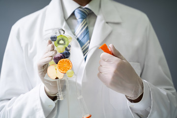 Doctor Holding Saline Bag With Fruit Slices Inside In Hospital