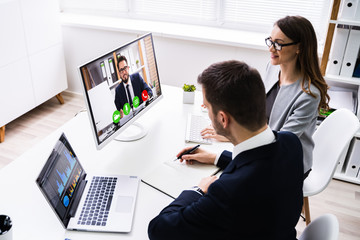Two Businesspeople Video Conferencing On Computer