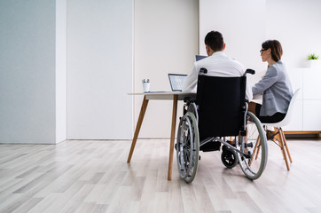 Disabled Businesswoman Sitting With Her Partner In Office