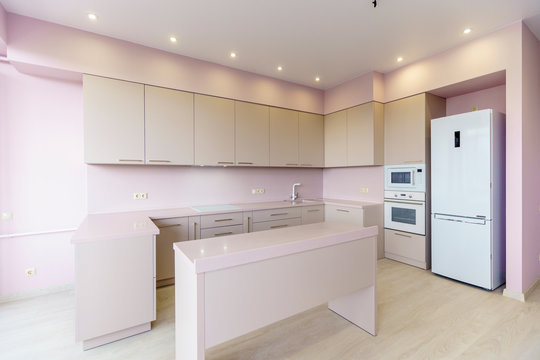 White New Kitchen Set. Kitchen Furniture Is New With All Kitchen Appliances. In Front Of The Kitchen Is A White Table. Fresh, New Renovation.