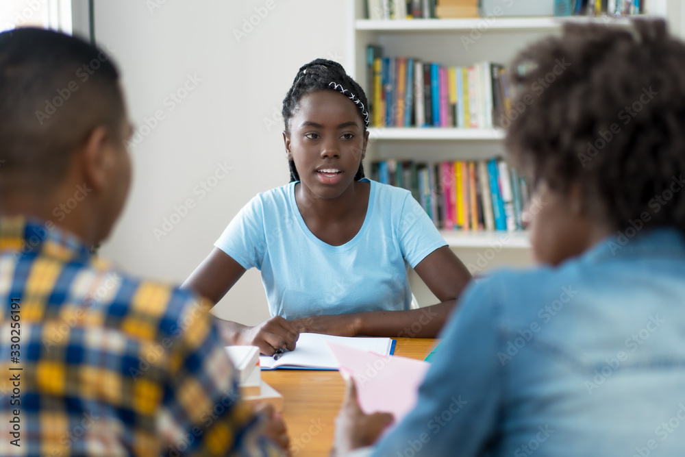 Wall mural afro american student talking with group of students