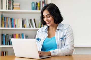 Mexican mature adult woman working at computer