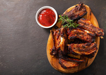 Grilled pork ribs with rosemary on a wooden board
