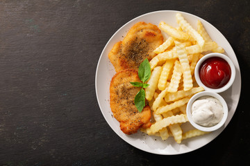 plate of chicken schnitzel and french fries, top view