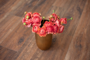 Elegance ranunculus bouquet on a wooden floor. Beautiful flowers composition in bright rosy colors. Perfectly for Birthday Celebration, Women's and Valentine's Day, Anniversary. Copy space. Top view.