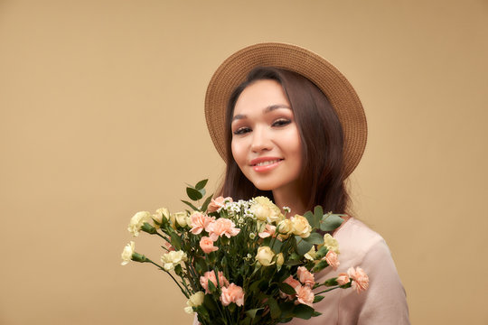 Creative fashion portrait of beautiful young woman with flowers