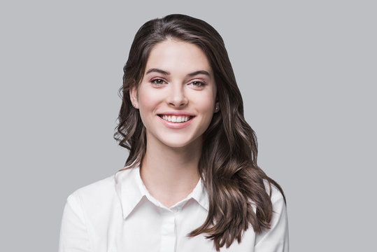 Beautiful young business woman portrait, Smiling cute girl with long hair studio shot, Isolated on gray background	