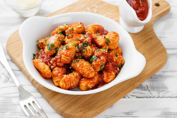 Homemade italian gnocchi with red tomato sauce and parmesan cheese. - obrazy, fototapety, plakaty
