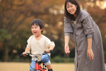 自転車に乗る練習をする親子