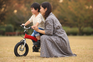 自転車に乗る練習をする親子