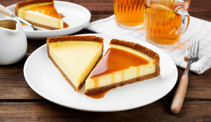 Cheesecake slices with caramel sauce on white plate. Slices of classic cheesecake. 