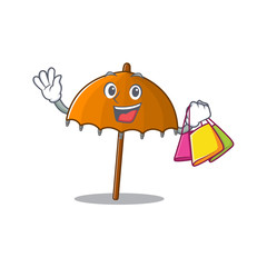 Happy rich orange umbrella mascot design waving and holding Shopping bag
