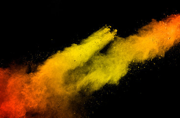 Abstract yellow orange powder explosion on white background. Freeze motion of yellow orange dust particles splash.