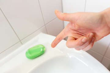 a woman washes her hands with soap