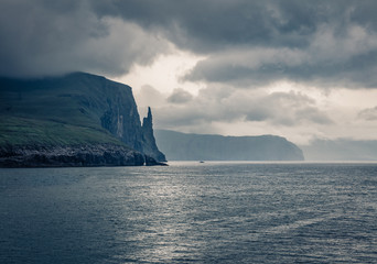 Obraz na płótnie Canvas Gorgeous Faroese landscape with Trollkonufingur cliffs on Vagar island. Dramatic summer scene of outskirts of Sandavagur village, Faroe Islands, Kingdom of Denmark, Europe.