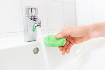 a woman washes her hands with soap