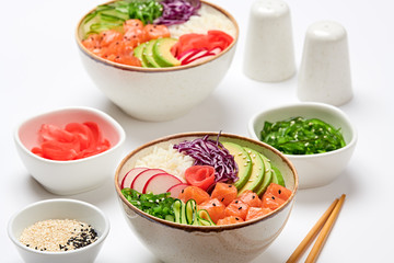 Hawaii salmon poke, avocado, rice, seaweed, cucumber, radish, carrot in bowl. Home made vegetarian...