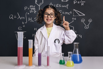 smiling scientist child in lab coat having an idea