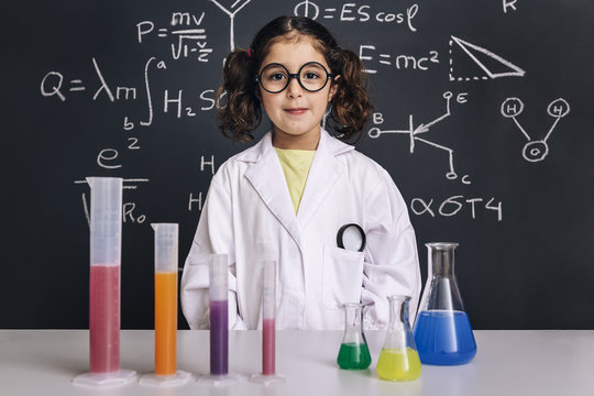 scientist child in lab coat with chemical flasks