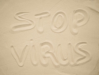  the inscription on the sand "stop virus"