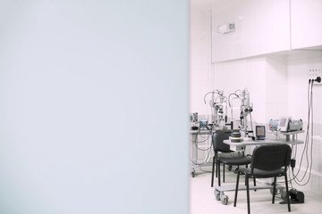 Open door to the new clean doctor's office of laser eye vision correction with a copy space