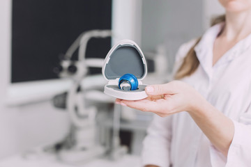 Ophthalmologist surgeon holds in his hands Indirect Ophthalmoscopy Lens which is used in ophthalmic for the general diagnosis of eye diseases and specifically for Selective Laser Trabeculoplasty